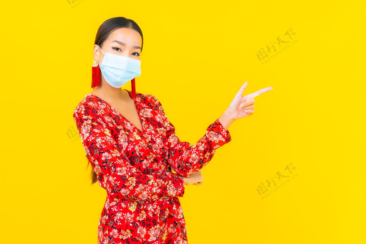 过滤肖像美丽的亚洲年轻女子戴上防冠状病毒或冠状病毒的面具在黄色的墙上危险空气穿着