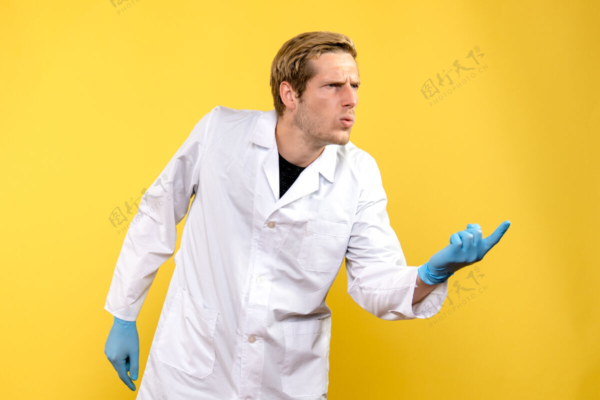 实验室正面图黄色背景上的男医生困惑的科维德-医院医护人员医生人服装