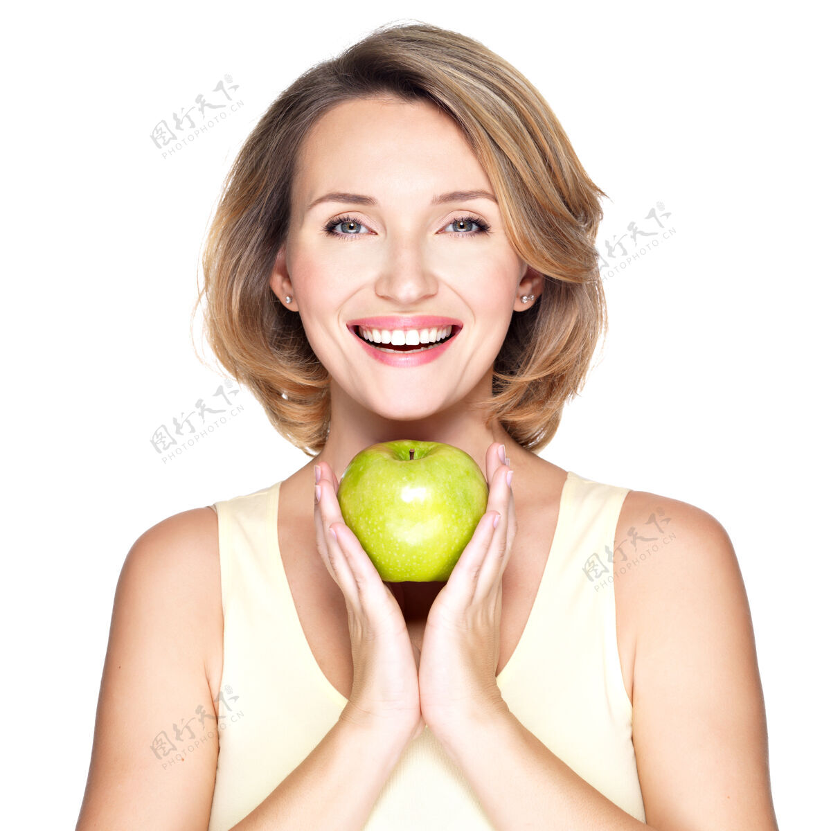 维生素年轻快乐的微笑着的女人 带着绿色的苹果-孤立在白色的土地上微笑年轻素食