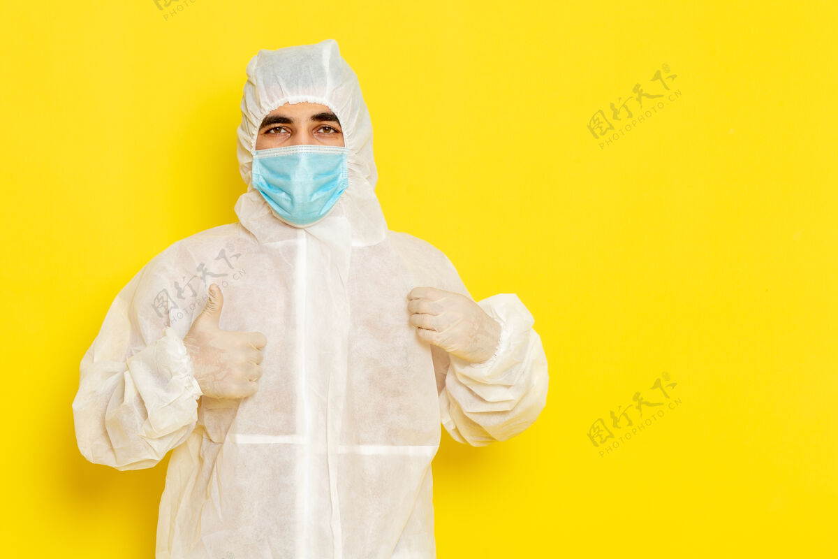 实验室身着特殊防护服 戴着面具的男性科学工作者的正面图 摆在淡黄色的墙上姿势科学危险