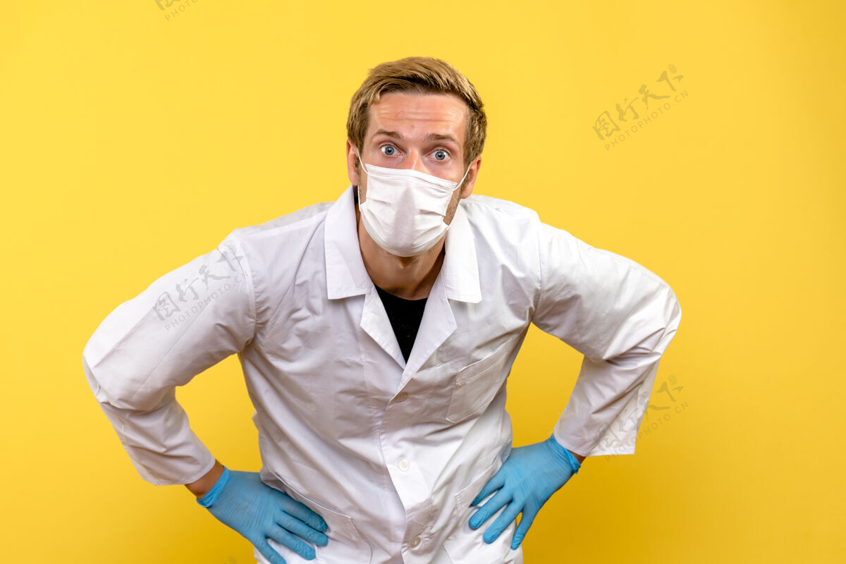 正面前视图男性医生只是在看黄色背景大流行的医疗保健病毒外观人流行病