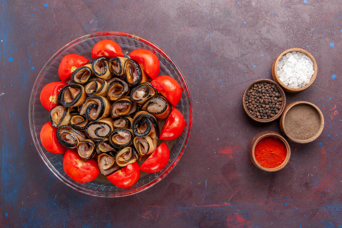 香料俯视图蔬菜餐切片和卷西红柿与茄子和调味品在黑暗的背景深色烹饪茄子