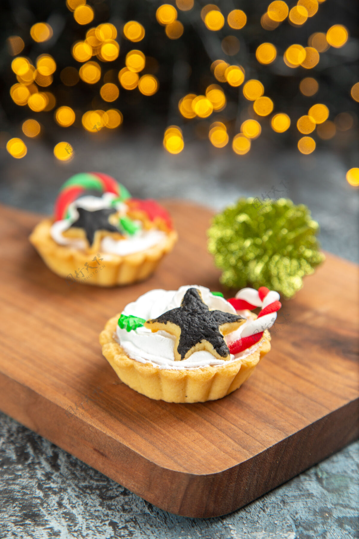 板前视图小馅饼在服务板上圣诞饰品在黑暗孤立的表面甜点餐厅菜肴