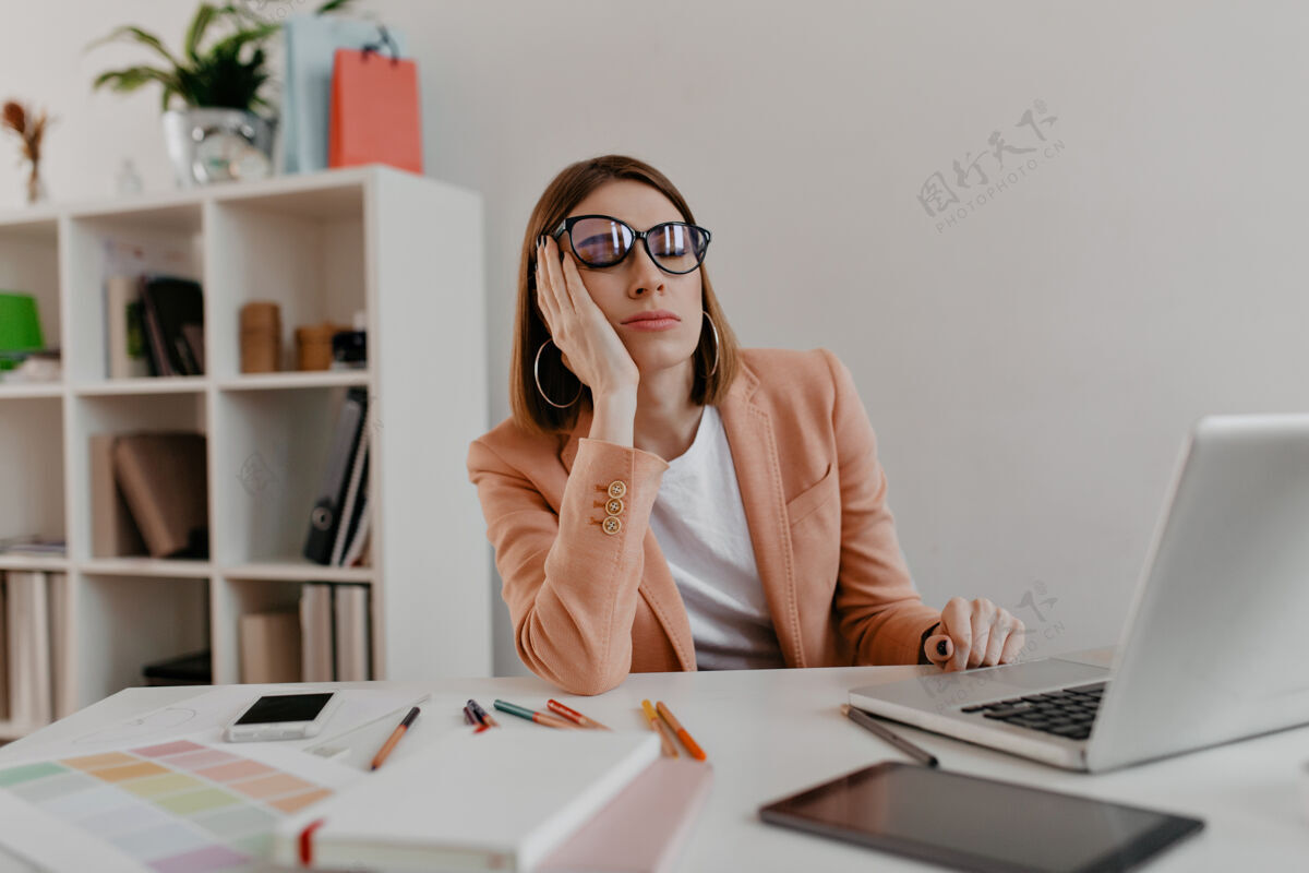 办公室疲惫的戴着眼镜的工人在工作场所睡着了白色办公室里穿着夹克的女士的画像企业家顾问成年人