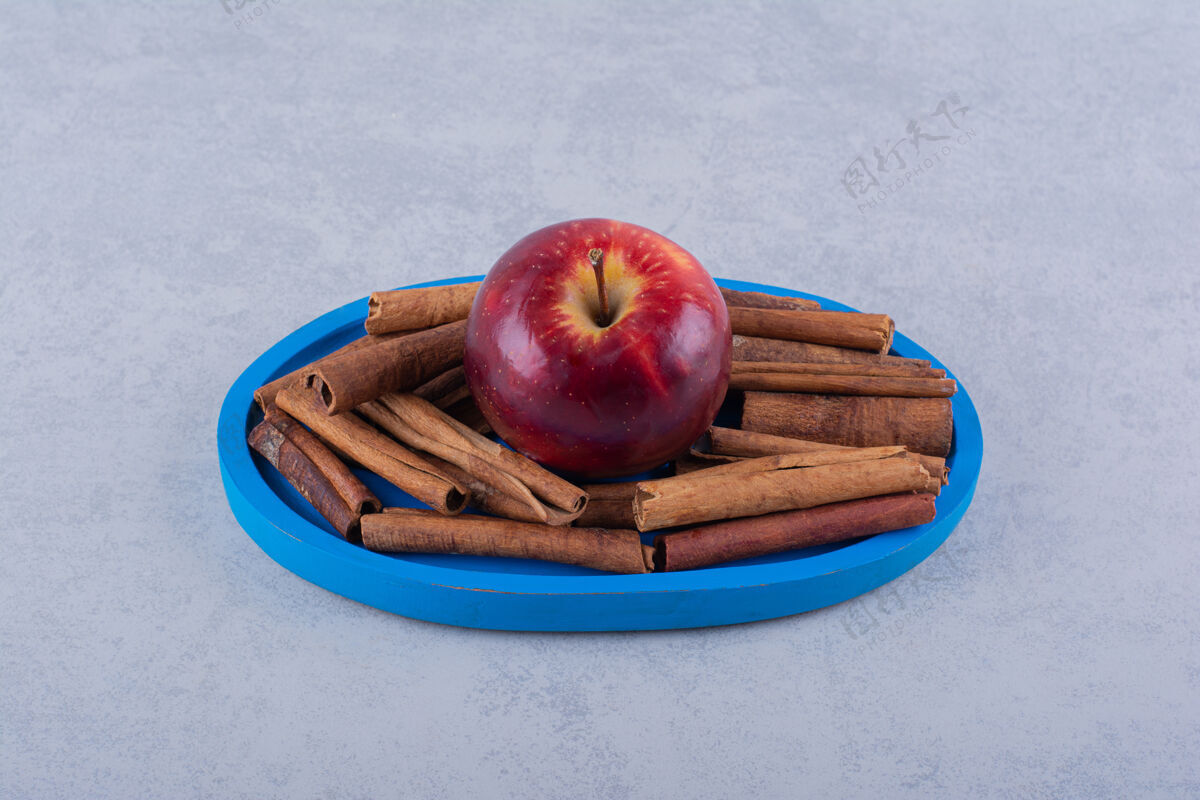 棒蓝色的盘子里放满了肉桂和苹果食品健康多汁