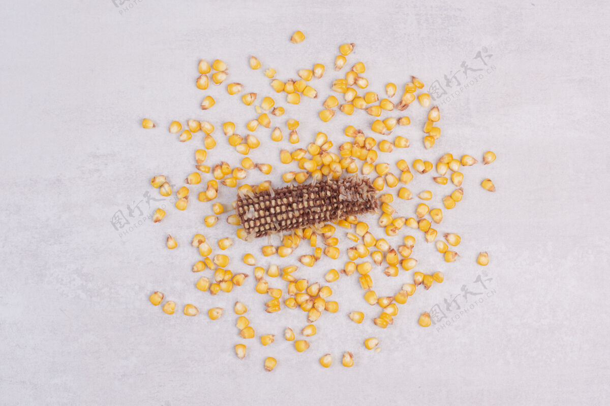 视图新鲜煮熟的玉米种子放在白色的表面上美味玉米棒种子