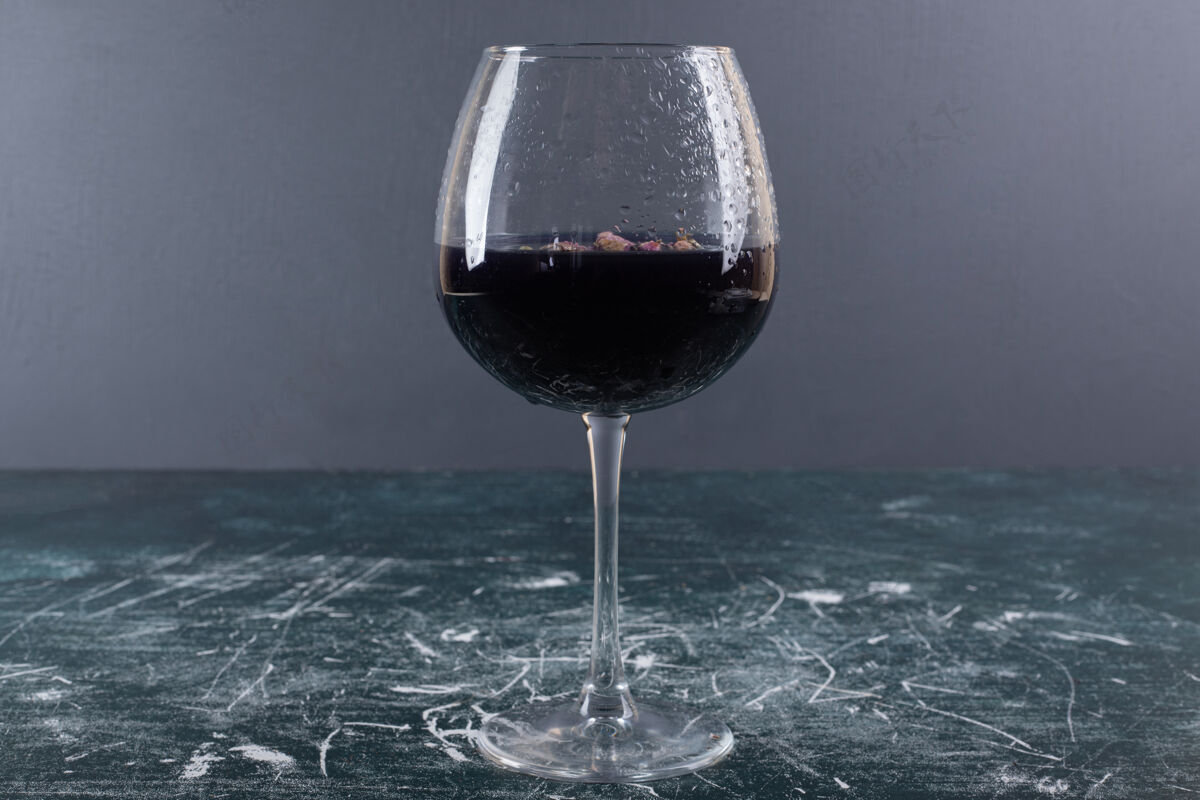 杯子蓝色桌子上放一杯加冰的葡萄酒滴酒桌子