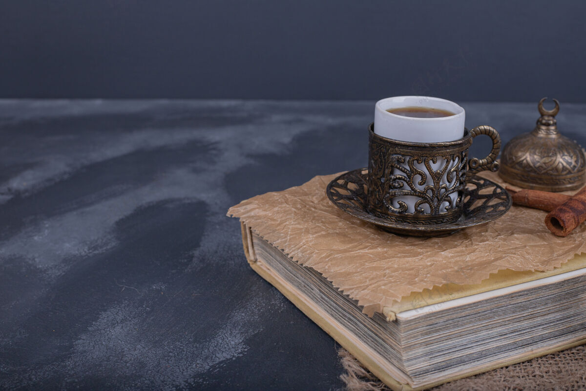 肉桂在书的上面放一杯咖啡和肉桂传统杯子饮料