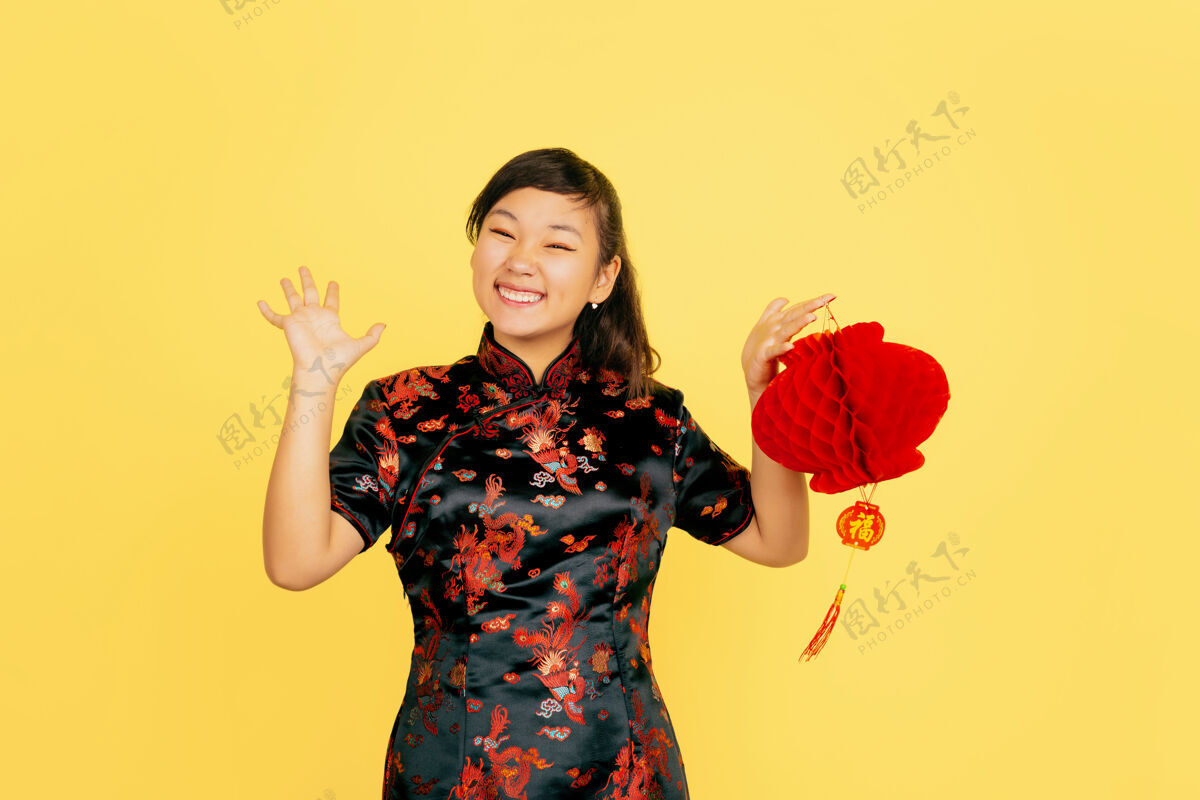 亚洲与灯笼合影 微笑 邀请中国新年快乐黄色背景上的亚洲少女肖像复制空间新年传统服饰