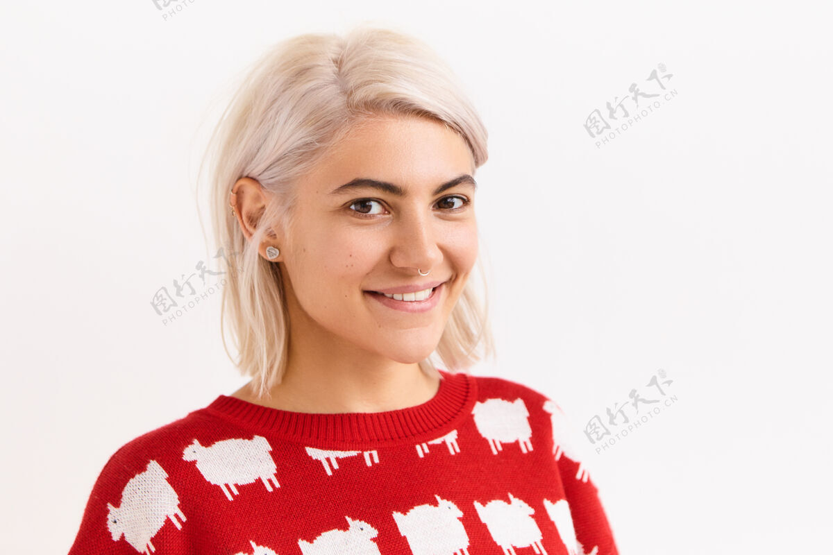 表情横图：美丽的欧洲女学生喜闻乐见好消息 得到一个标记 穿着红色毛衣摆出孤立的姿势 带着可爱的微笑 露出直直的牙齿时尚幸福肖像