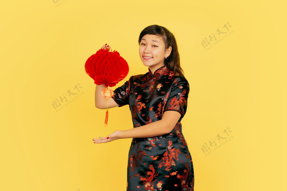 欢呼与灯笼合影 微笑 邀请中国新年快乐黄色背景上的亚洲少女肖像复制空间红色传统服装