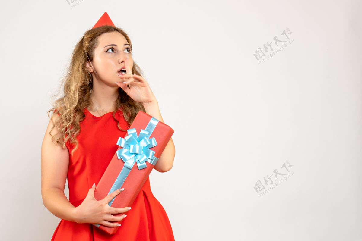 情感正面图身着红色连衣裙的年轻女性用礼物庆祝圣诞节美丽夏娃年轻女性