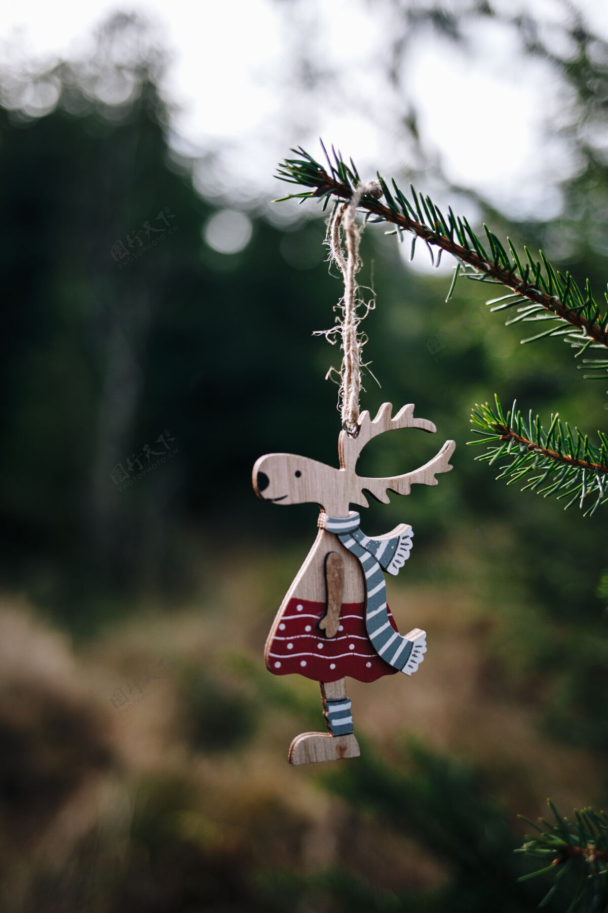 自然挂在圣诞树上的玩具鹿的垂直镜头夏娃年季节