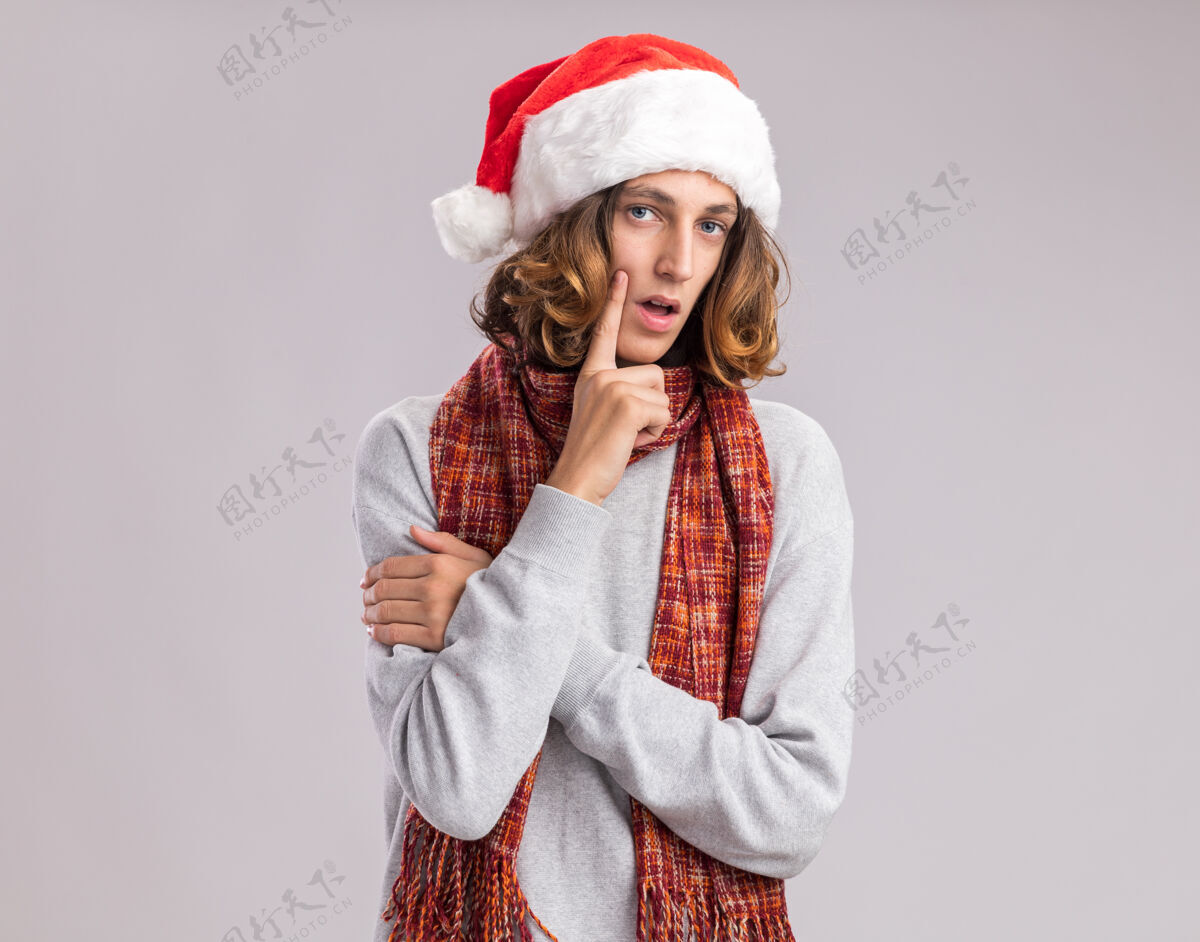 围着年轻人戴着圣诞老人的帽子 脖子上围着暖和的围巾 神情沉思地思考着圣诞快乐新的沉思
