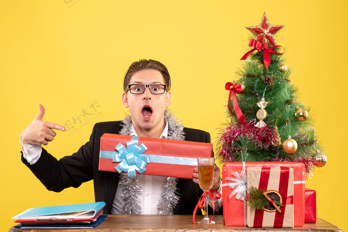 喜剧演员正面图男工人坐着拿着圣诞礼物礼物工作男工人