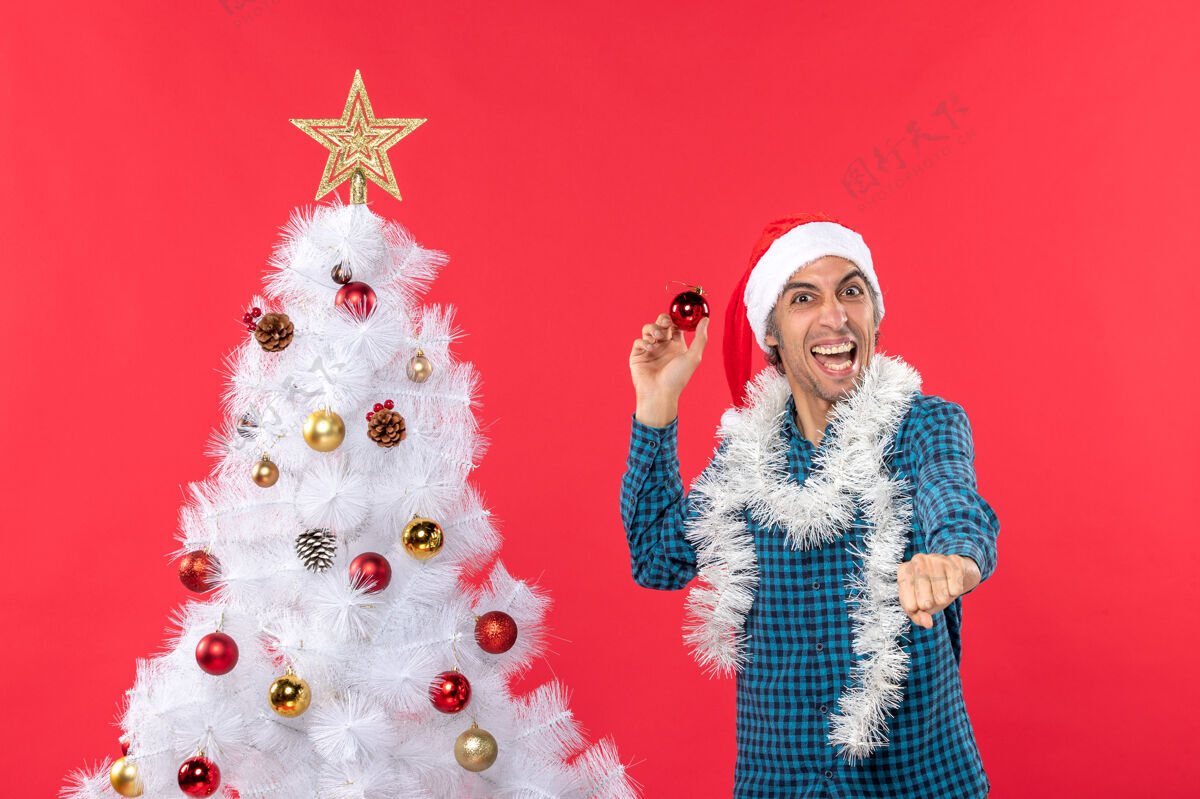 配件一个带着圣诞老人帽子 穿着蓝色条纹衬衫 满脸笑容 情绪幽默 充满自信的年轻人情绪化年轻人男人