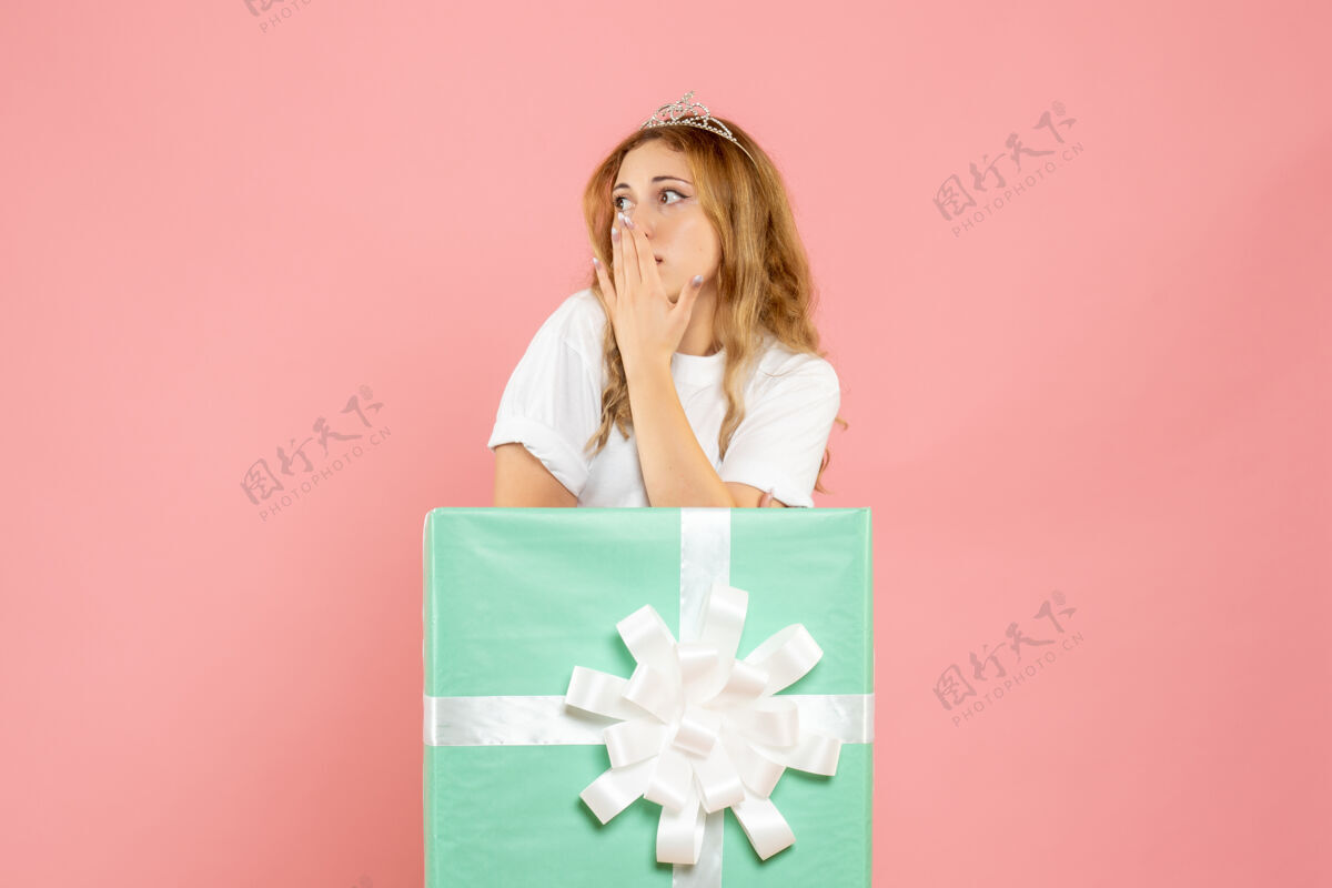 蓝色蓝色礼品盒内的年轻女性正面图人年份女孩