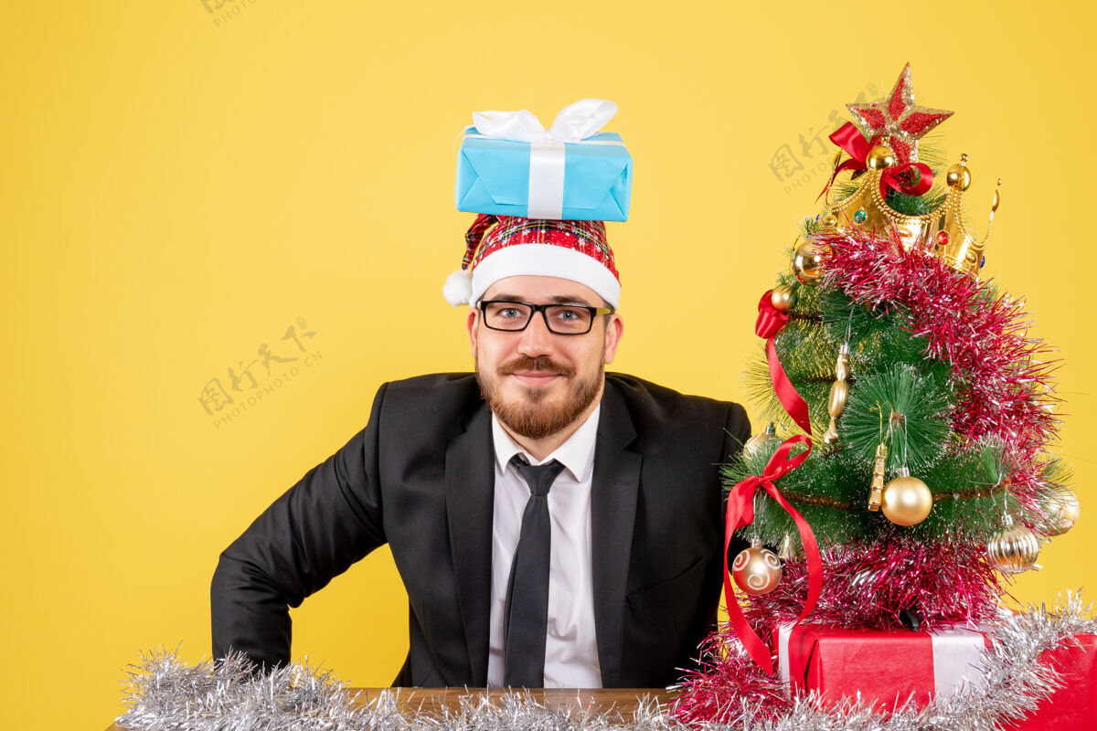 新郎正面图男性工人围坐在黄色的圣诞礼物上情感周围西装
