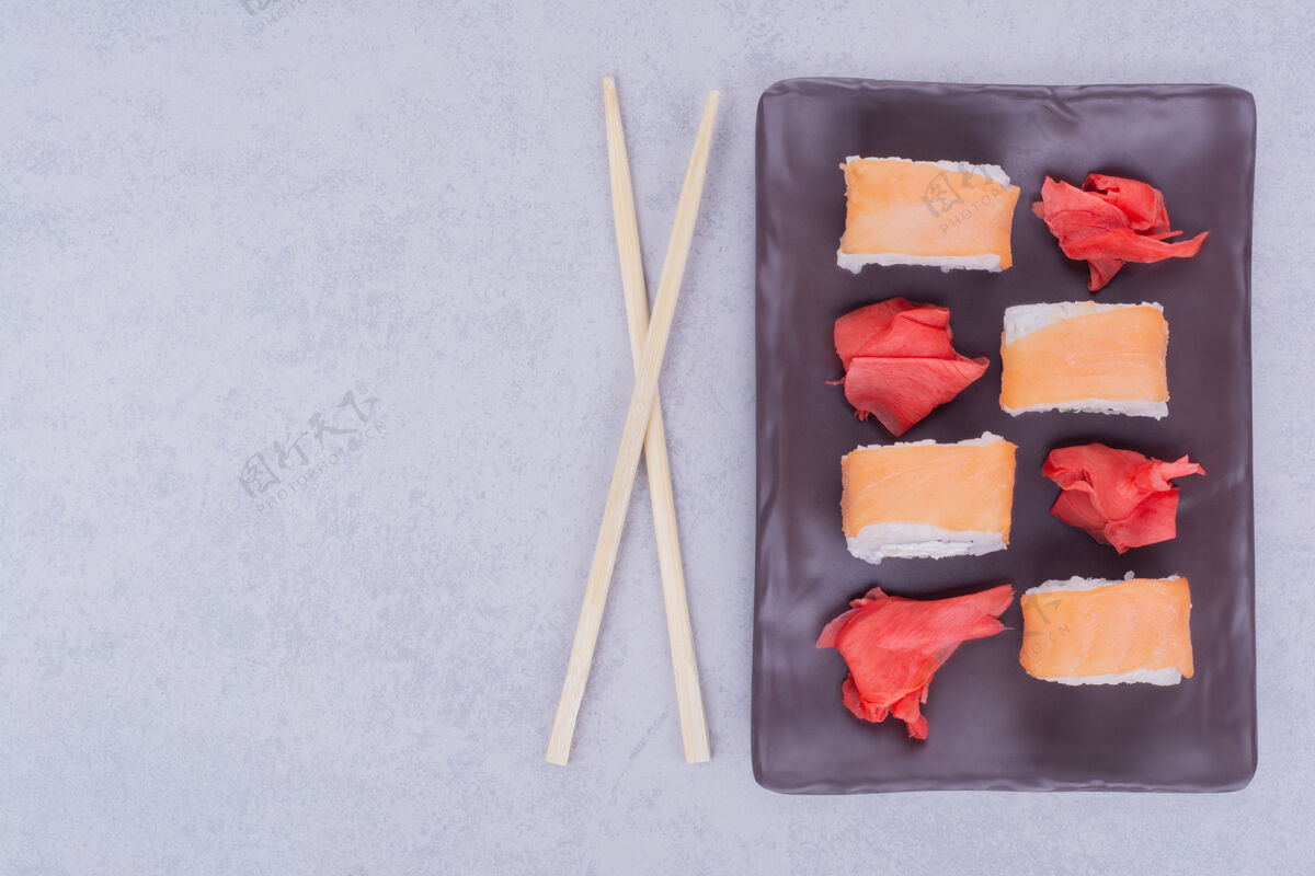 日本黑色陶瓷盘中的鲑鱼寿司卷顶部食品亚洲