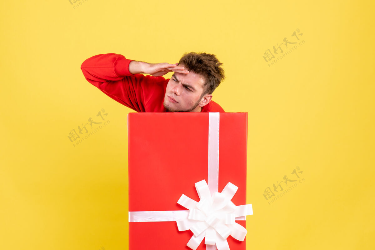 人正面图年轻男子藏在礼品盒内圣诞微笑年轻