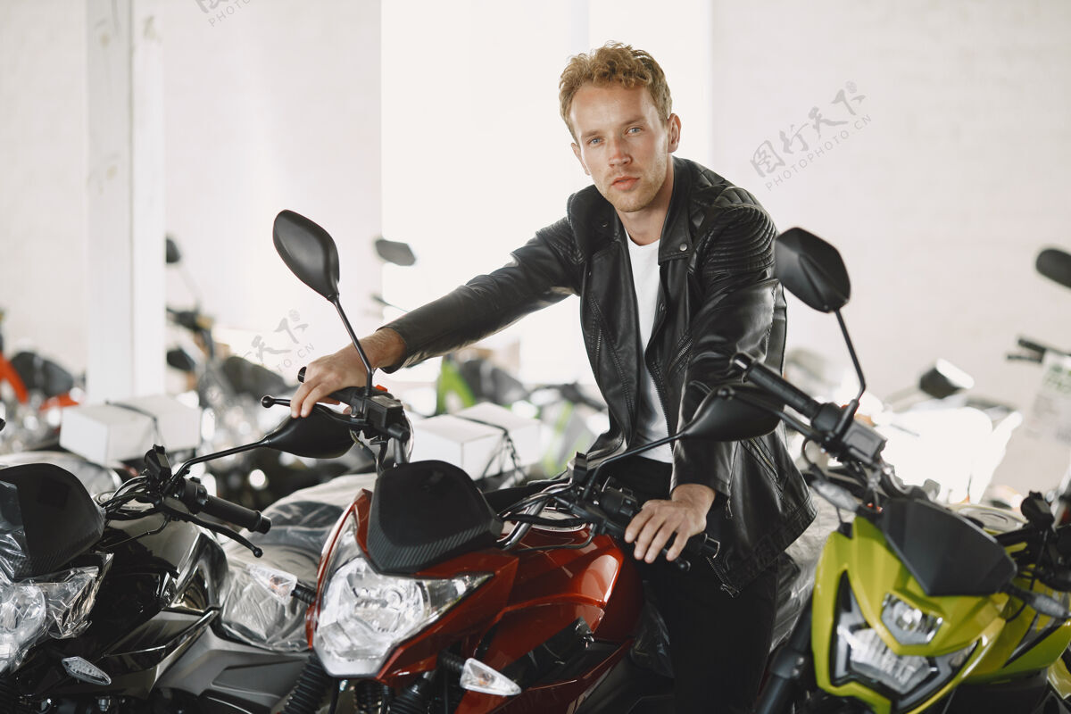 经销商一个男人在摩托店里选了摩托车一个穿黑色夹克的家伙展示骑手商店