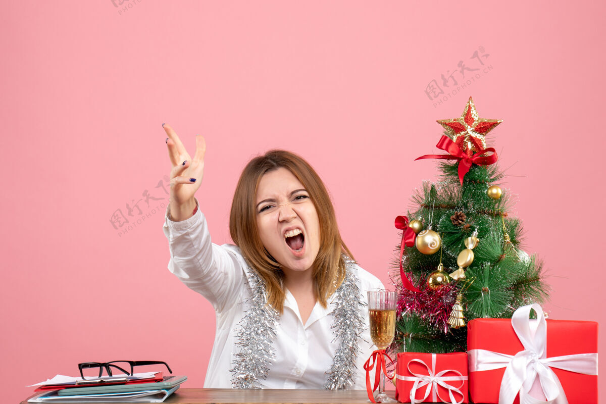 女女工坐在桌子后面的正面图 粉色的礼物花礼物桌子