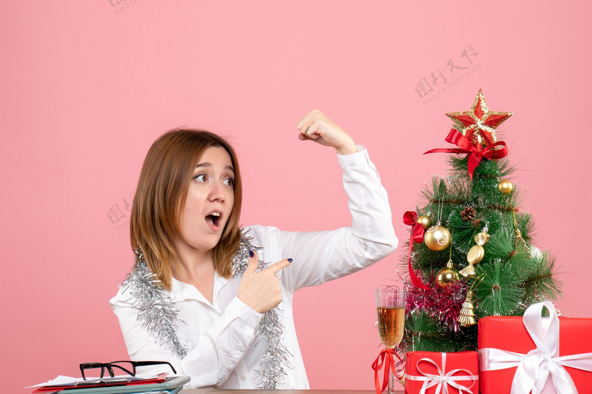 工人女工人坐在桌子后面 粉色的圣诞礼物坐着女工礼物