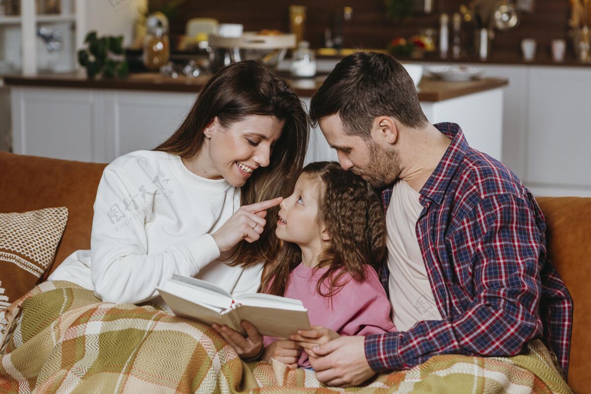 人爸爸妈妈和女儿在沙发上看书沙发女人阅读