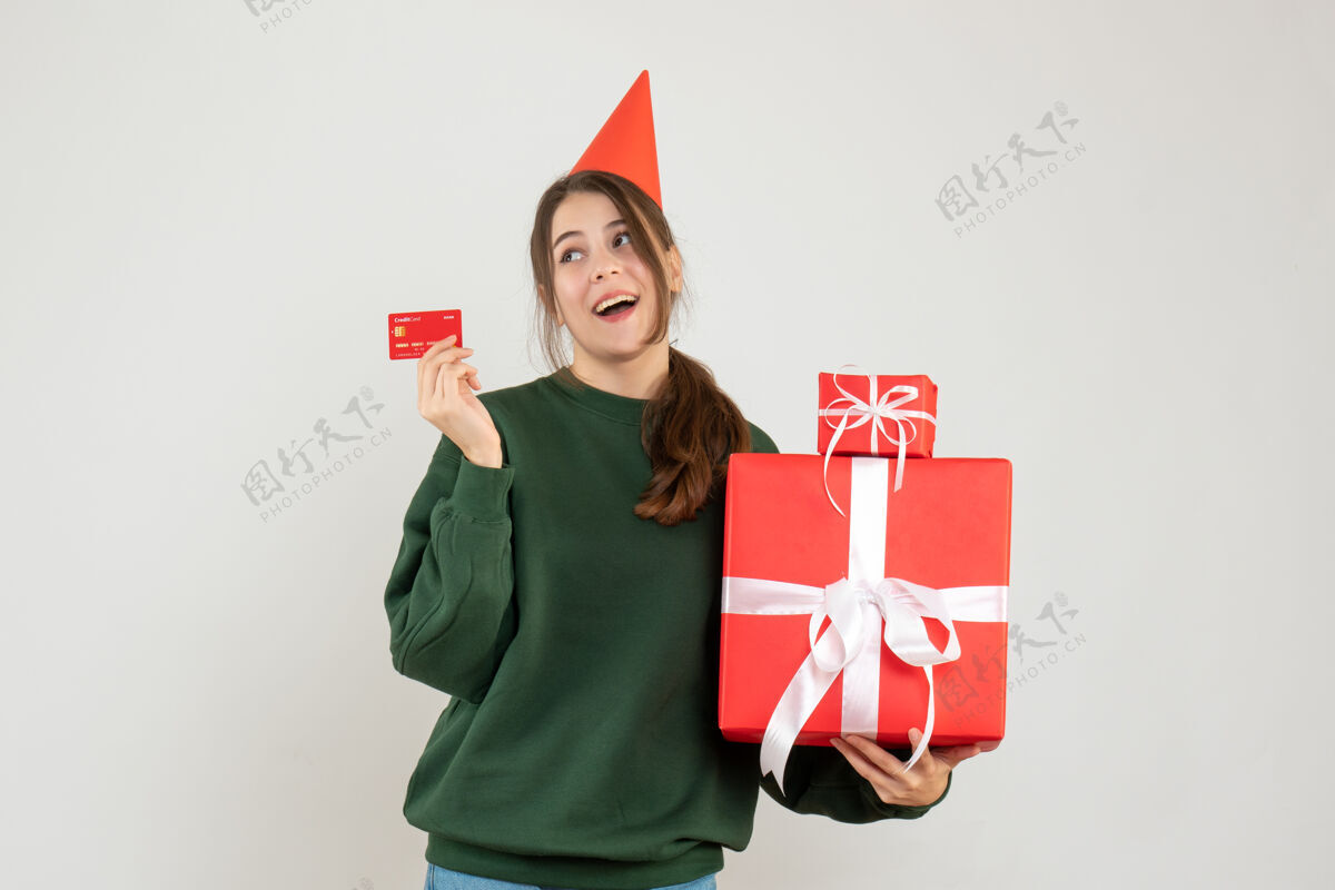 圣诞节戴着派对帽的快乐女孩拿着礼物和白色卡片帽子举行人们