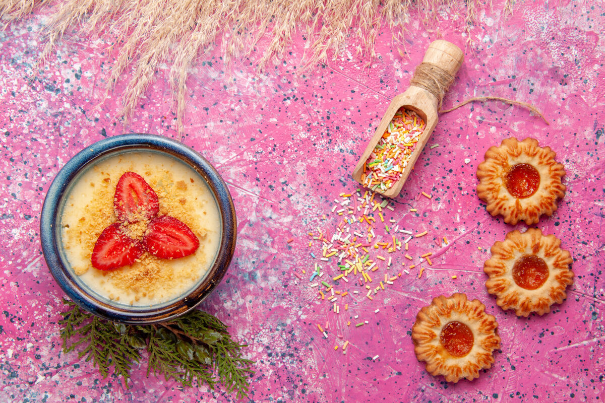 背景顶视图美味的奶油甜点与红色切片草莓和饼干浅粉色背景甜点冰淇淋甜浆果饼干奶油甜点