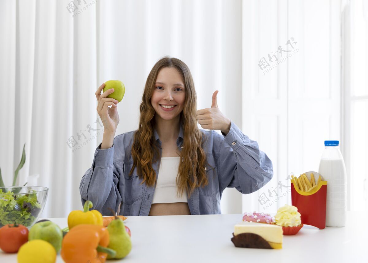 食品拿着苹果和拇指的中枪女人健康营养模特