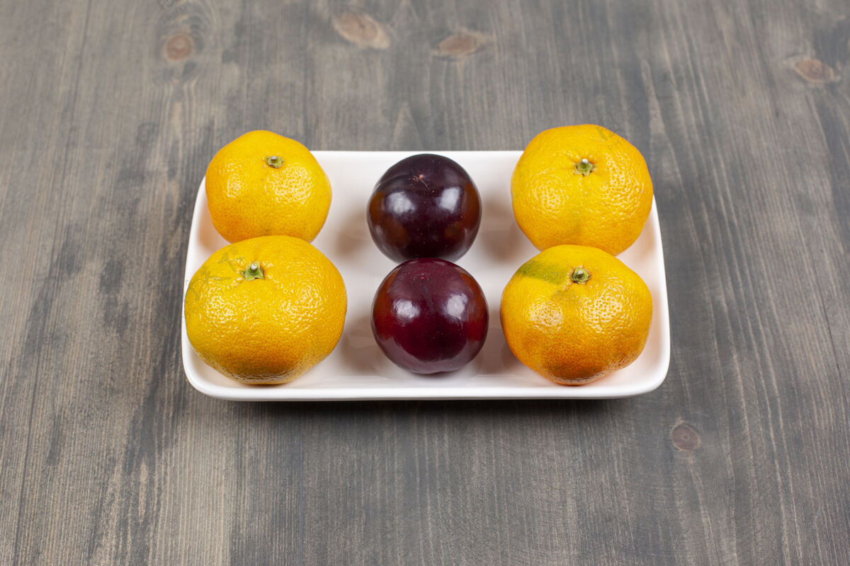 生的木桌上的甜橘子和李子高质量的照片柑橘健康许多