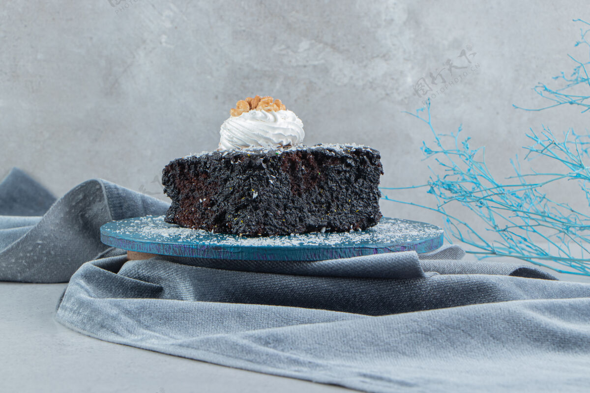 糖巧克力蛋糕涂上香草粉在大理石背景上的一块小木板上蛋糕烘焙甜点