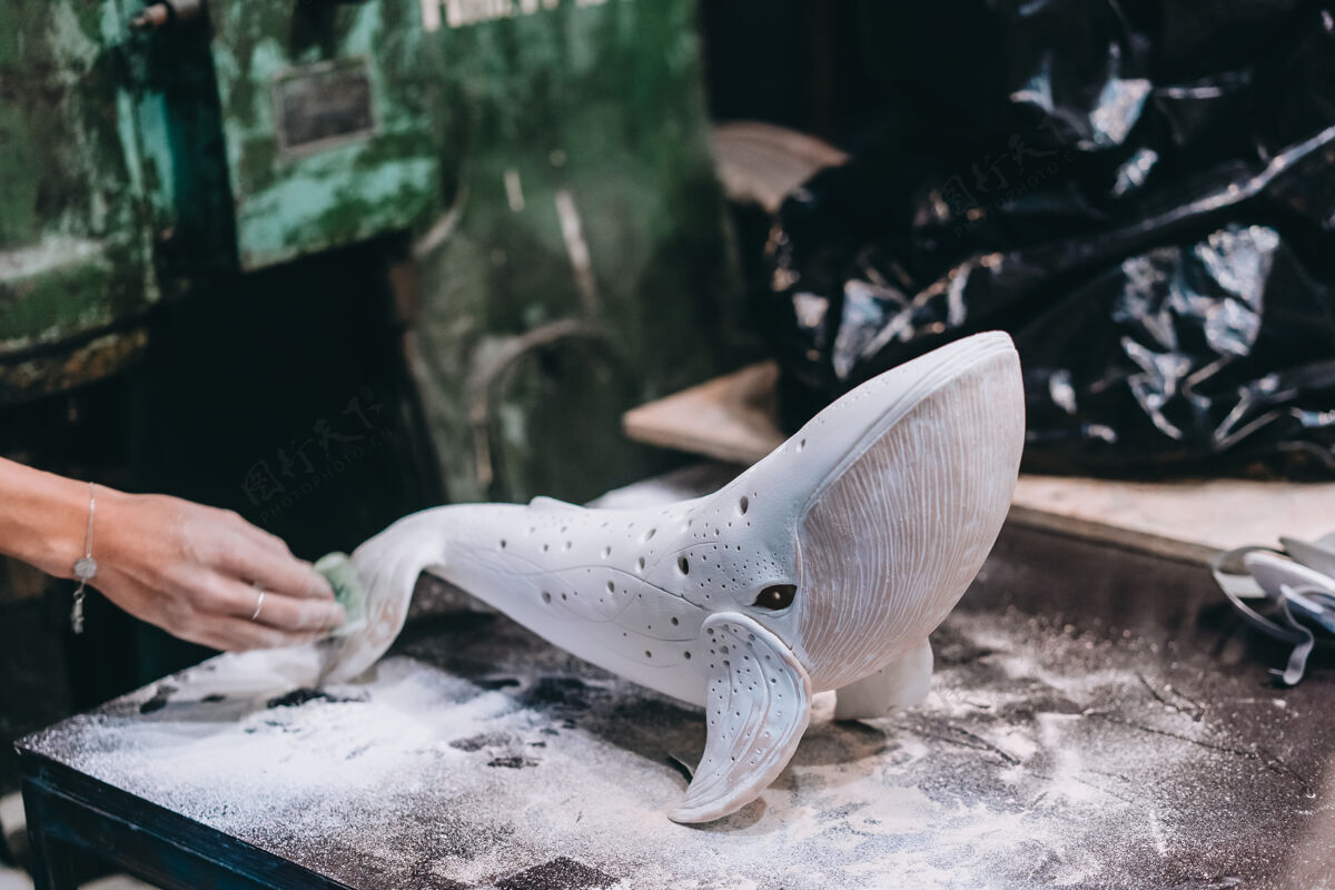 工具一幅年轻女子在车间里享受最喜爱的工作的画像波特小心翼翼地在陶瓷鲸鱼上工作灵感微笑艺术