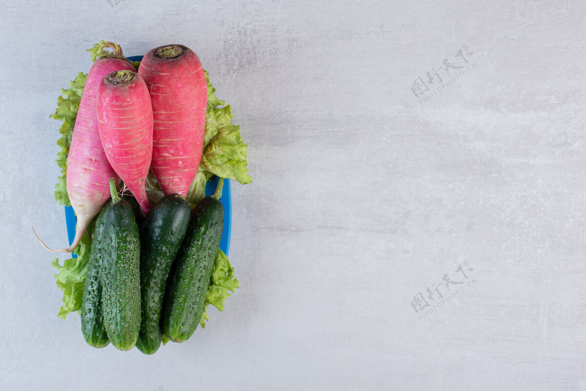 盘子健康的黄瓜和红萝卜放在蓝色的盘子里高质量的照片植物生菜什锦