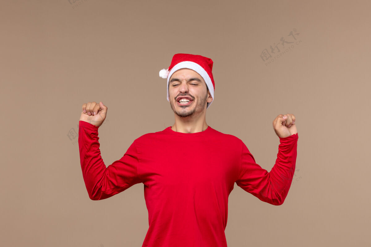 人前视图年轻的男性打哈欠的棕色背景圣诞情感节日男性开朗男性微笑
