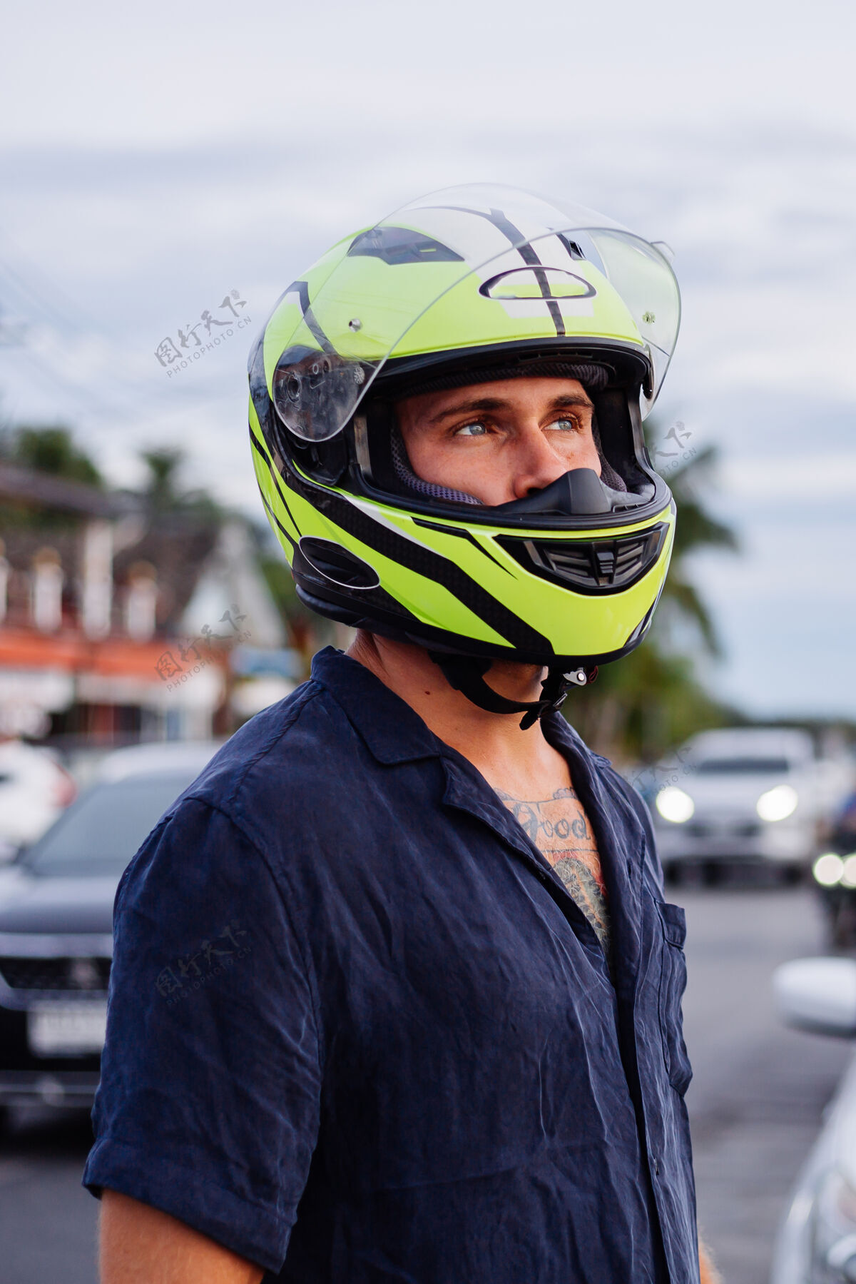 假期日落时分 在泰国繁忙的公路边 一位戴着黄色头盔的男子的画像异国情调比赛人