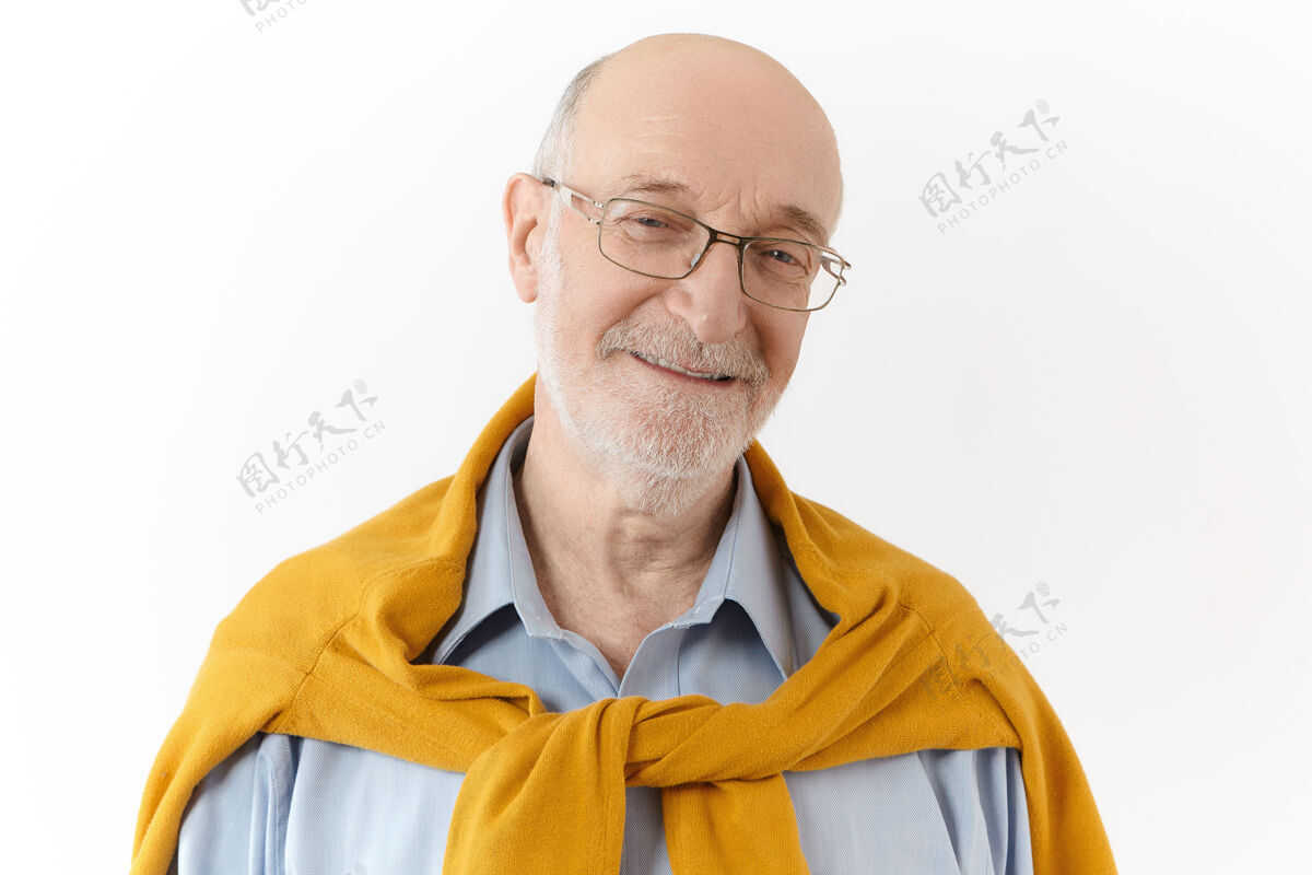 站立积极的人类情感 情感和态度照片中的快乐迷人的退休男性留着白胡子 秃头 表达着喜悦和喜悦 面带愉快友好的微笑看着镜头50岁成熟专业