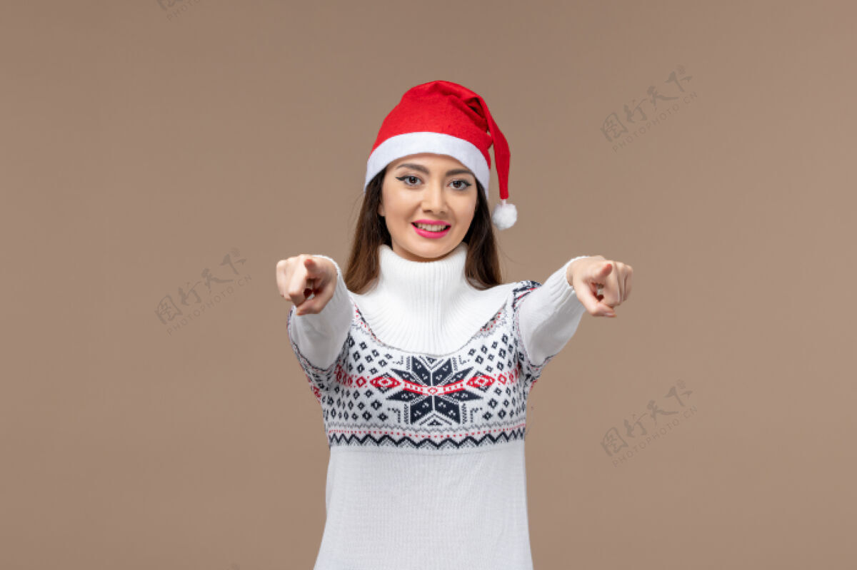 女人正面图：棕色背景的年轻女子 带着微笑的表情圣诞节背景人物模特