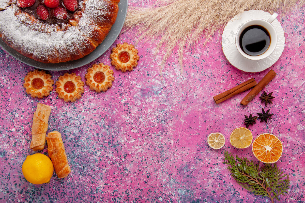茶俯瞰美味的草莓蛋糕糖粉蛋糕配上柠檬饼干和一杯茶 背景是粉色蛋糕甜甜的糖饼干馅饼杯子粉末柠檬