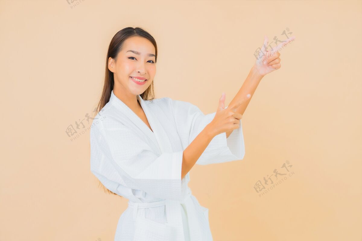皮肤肖像美丽的亚洲年轻女子穿着米色的微笑浴袍时尚浴缸自然