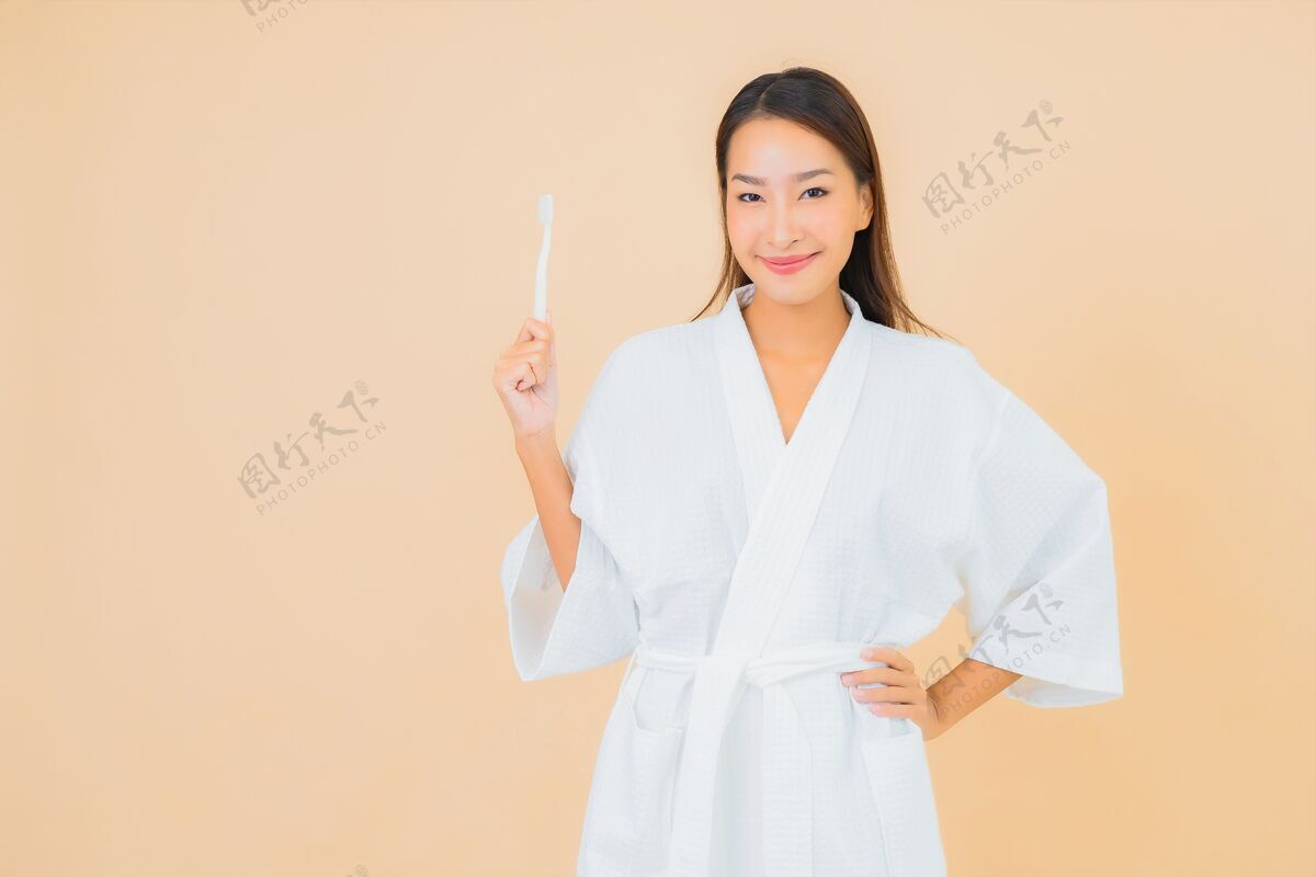 光用米色牙刷描绘美丽的亚洲年轻女子灰色蛀牙新鲜