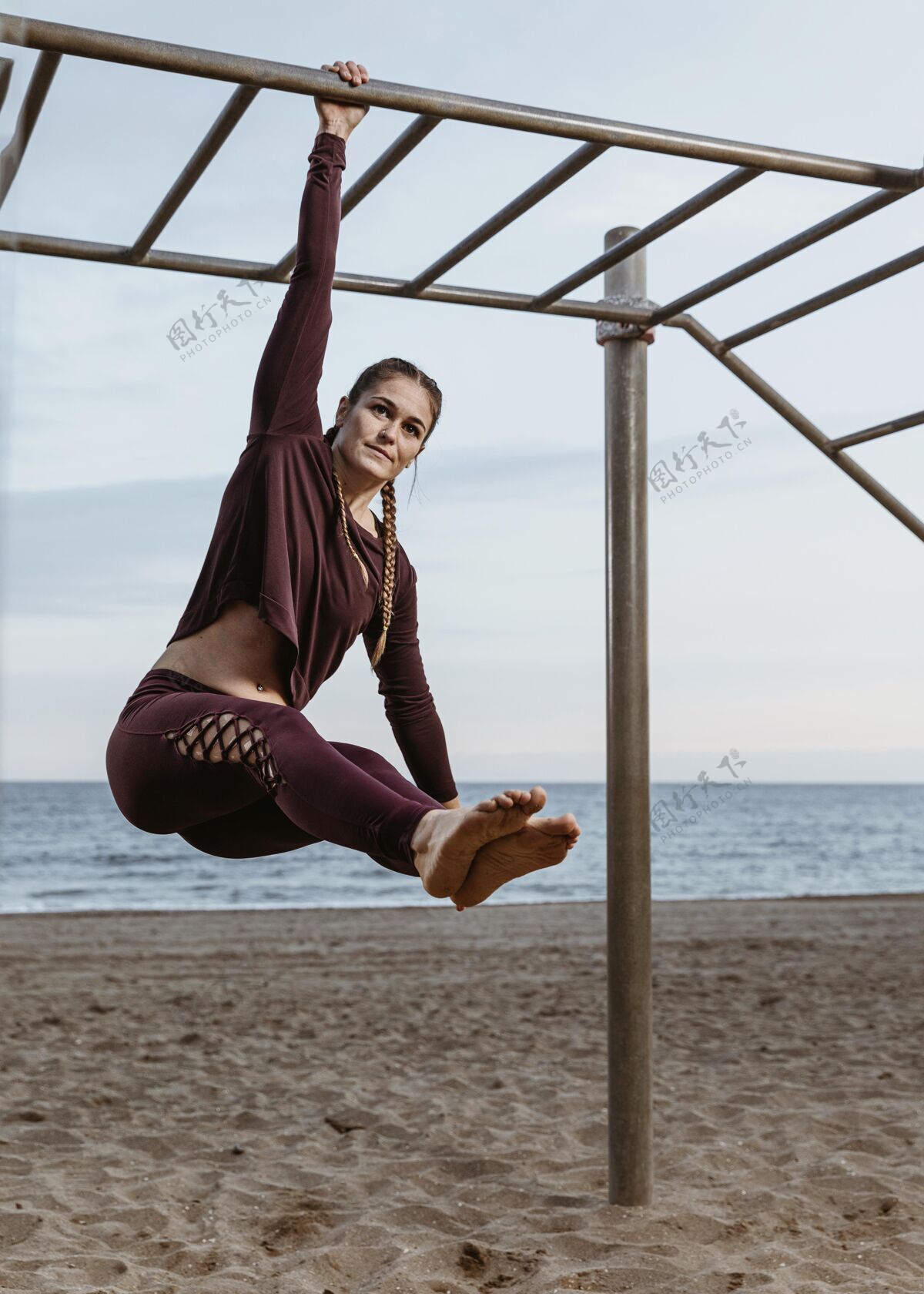 锻炼活跃的女人在海边做户外健身操活动健身垂直