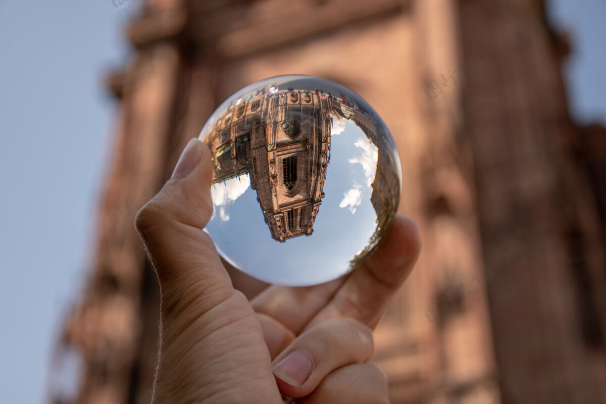 神秘特写镜头一个人拿着一个水晶球与历史建筑的反映神奇历史闪闪发光