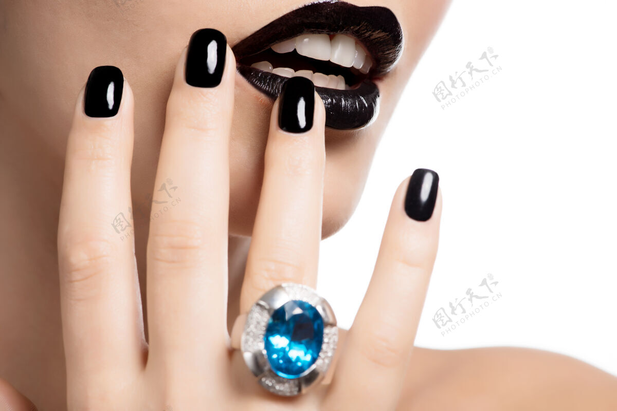 戒指一个女人的嘴唇和指甲被涂成亮黑色的宏观照片女性水晶配件