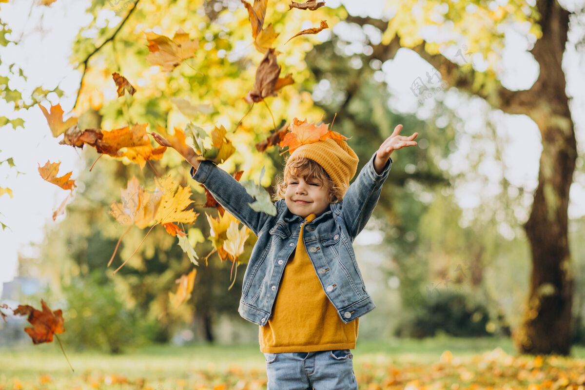 甜蜜可爱的男孩在秋天公园玩树叶树叶玩耍帽子