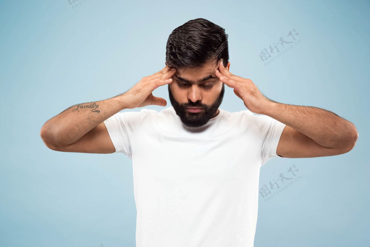 一半穿着白衬衫的印度年轻人的特写肖像注意力集中 头痛表情男性集中精神