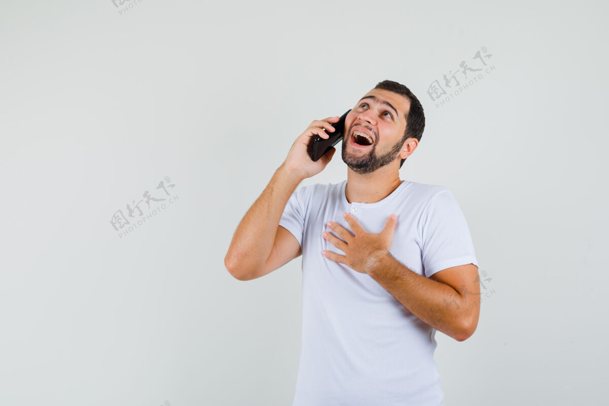 手势一个穿着白色t恤的年轻人在打电话 看上去很尴尬 正对着屏幕空间是文本男性表情人
