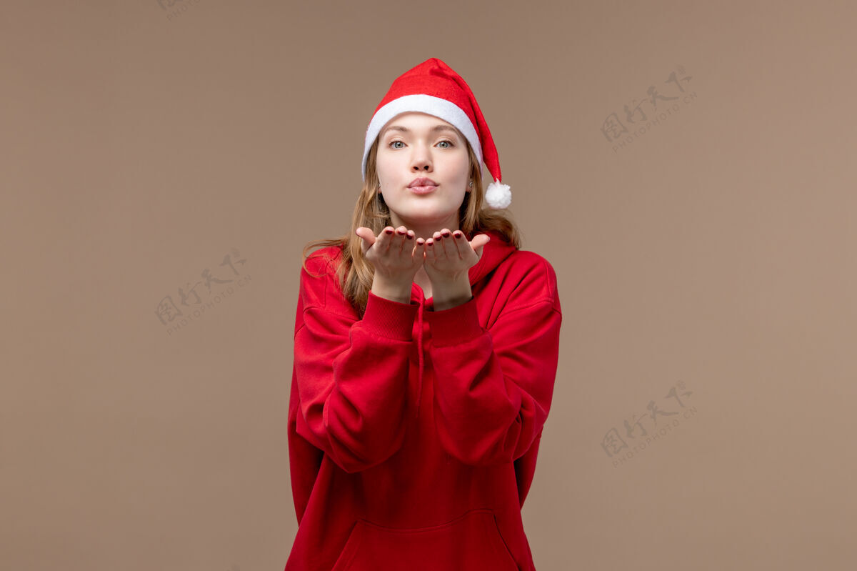 亲吻前视图圣诞女孩送上棕色背景的女人节日圣诞节飞吻棕色圣诞节美丽
