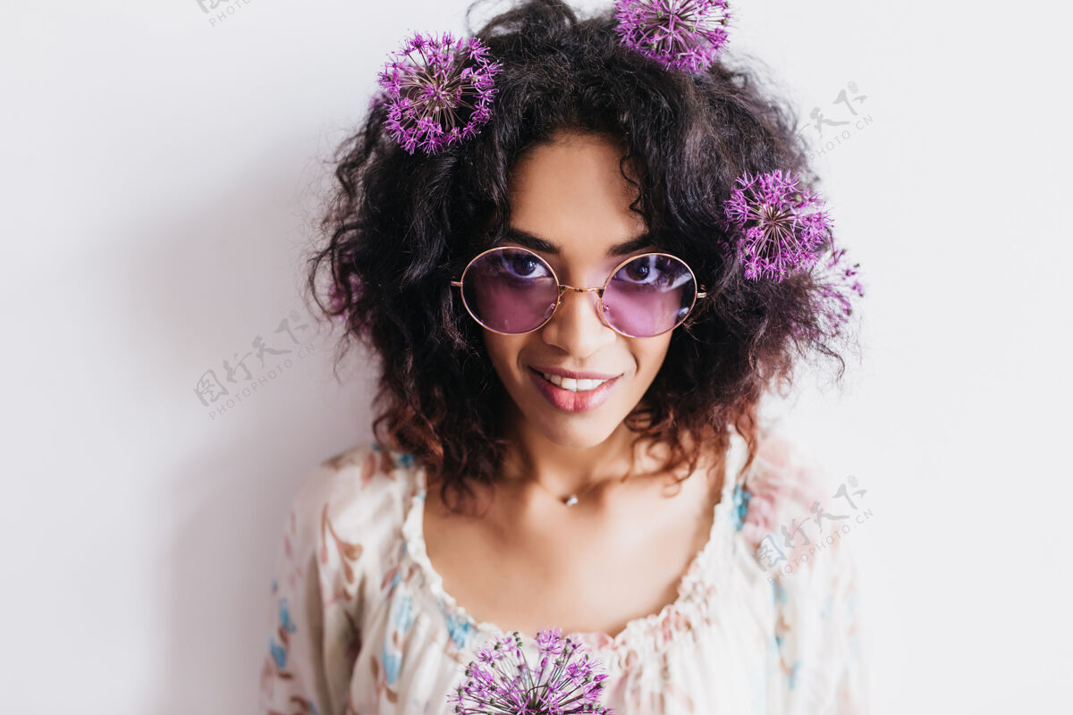 成人迷人的黑人女孩与葱合影的肖像美丽的非洲女模特手持紫色花朵微笑的室内照片非洲黑色肖像